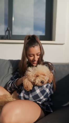 woman holding a puppy on a couch