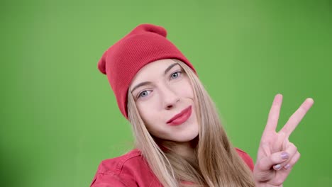 woman in red beanie taking selfie on green screen