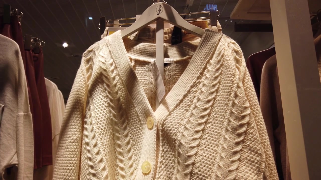 Clothes in shop. Shopping. Sweaters, shirts, jackets.