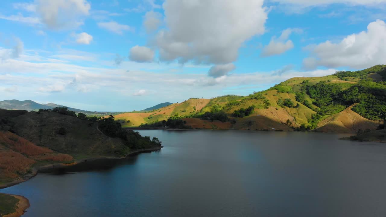 댐을 드러내는 산 사이의 호수를 통해 비행하는 공중 드론 샷