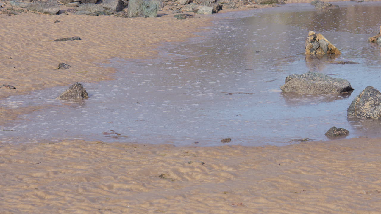 Shot of the High tide coming in over dry sand