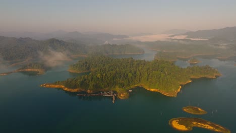 4K-Luftaufnahmen-Von-Schwebenden-Räumen-Im-Kao-Sok-Nationalpark-Bei-Sonnenaufgang,-See-Und-Bergen,-Thailand,-Asien