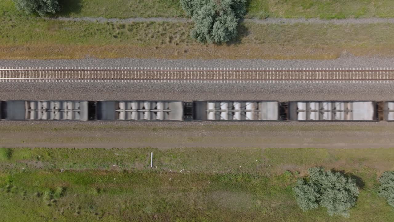 Aerial view of a train on tracks in a scenic, green landscape