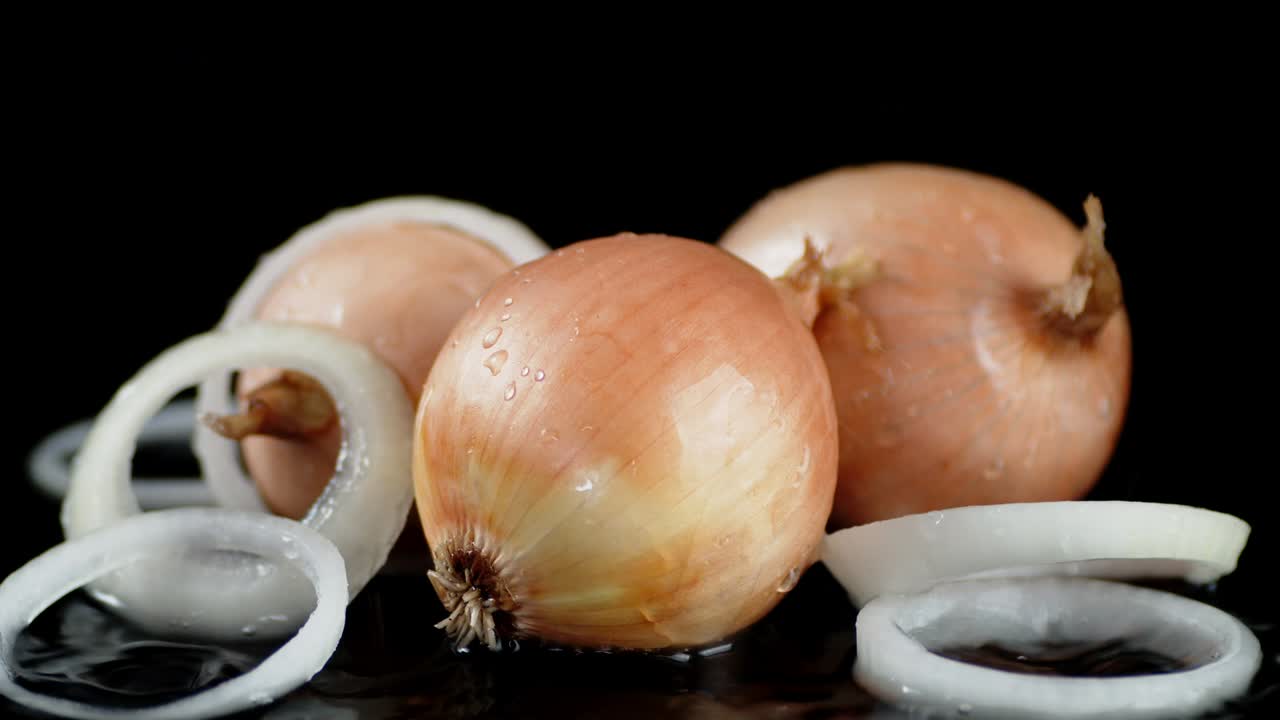 On the whole onions and onion rings falling water drops.