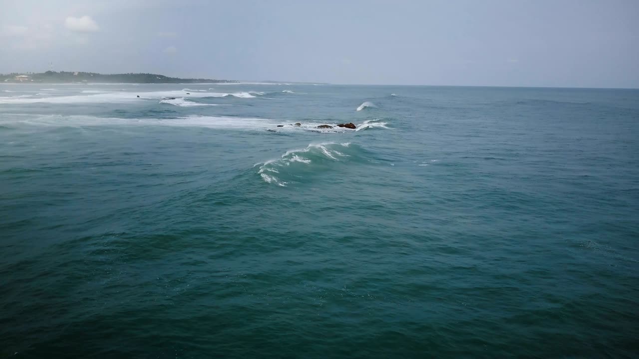 드론 카메라가 왼쪽으로 돌고 큰 바다 파도가 해안에 도달하고, 구름이 많은 폭풍의 날에 어지고 추락합니다.