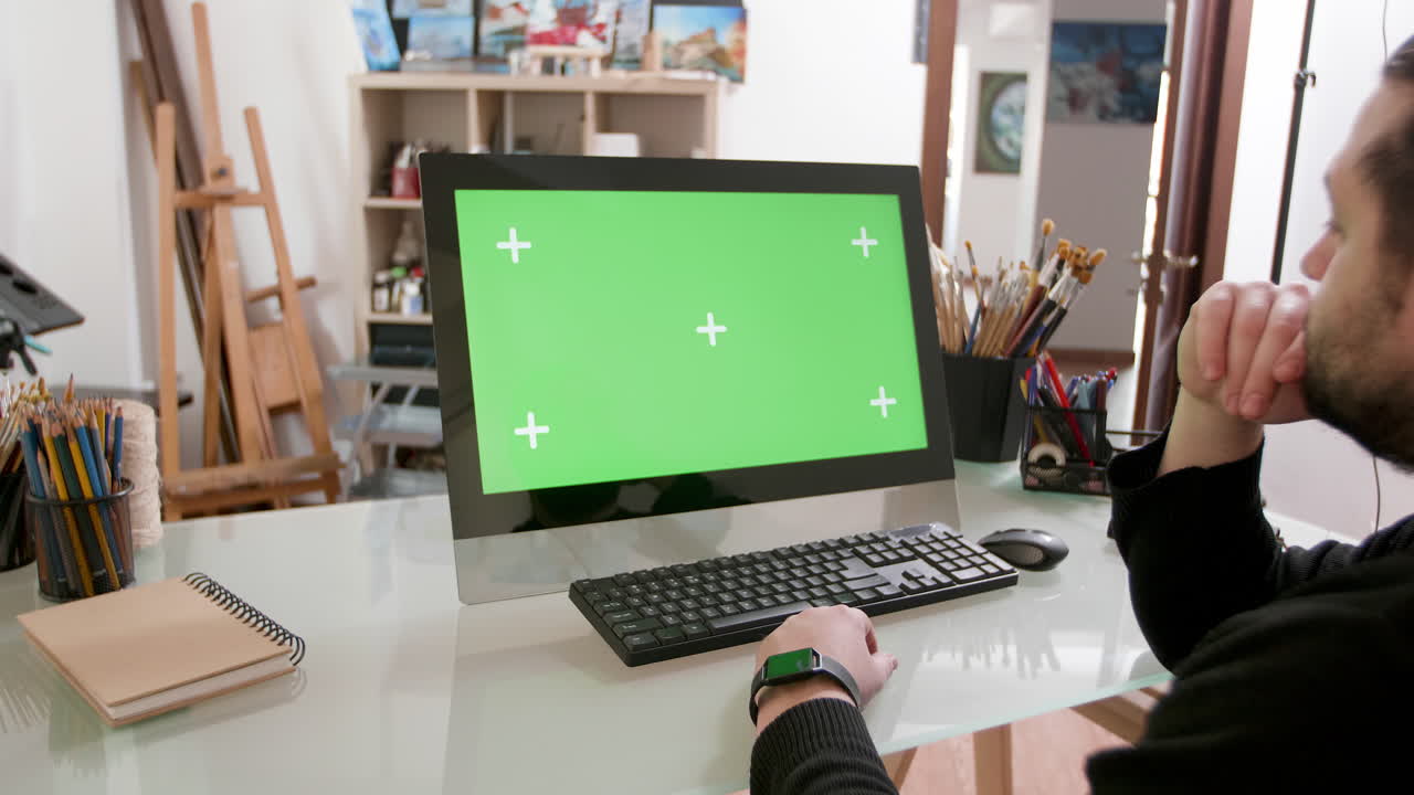 Computer with green screen in artist's studio
