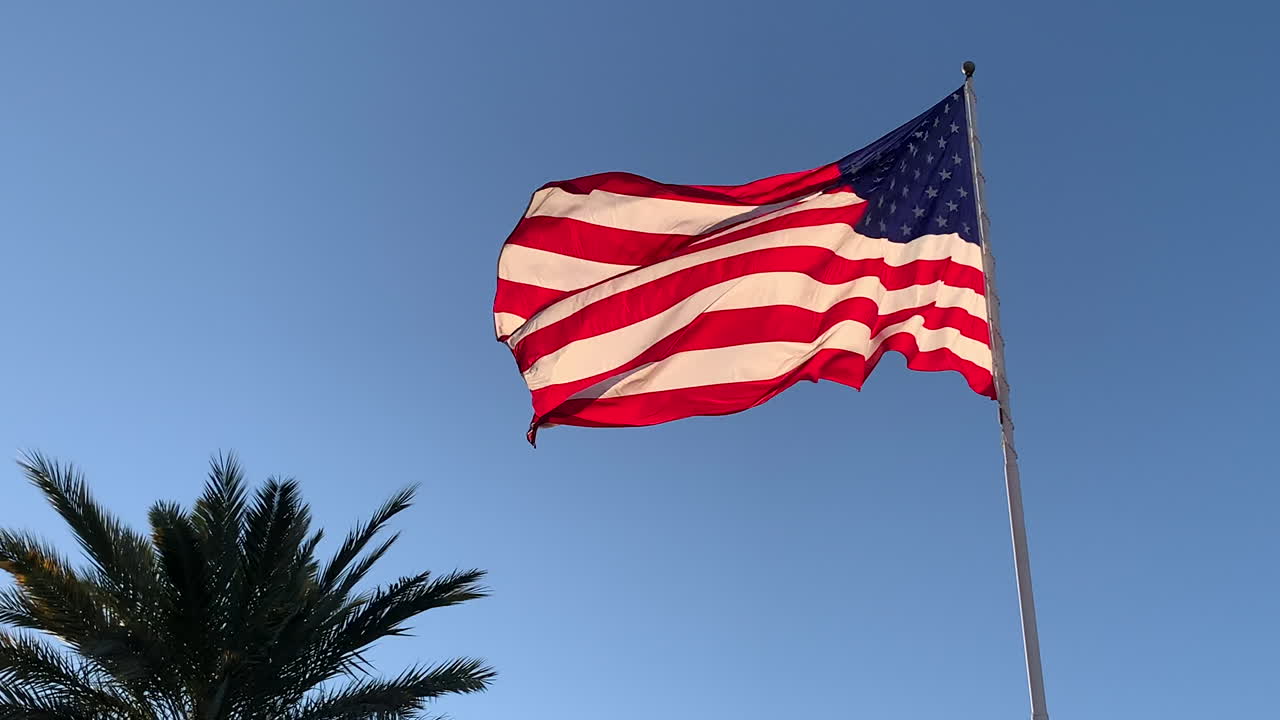 Vista dal basso della bandiera americana che sventola al vento, in slow motion.