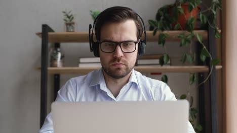 Focused young businessman working on computer at home.
