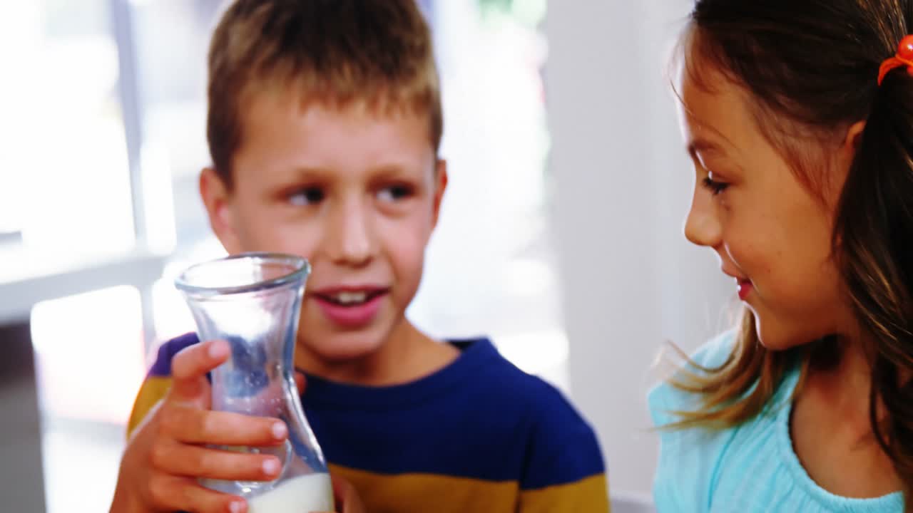 소녀 는 부 ⁇  에서 시리얼 그 ⁇  에 우유 를  ⁇ 고 있다