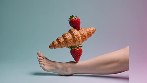 croissant and strawberries balanced on a leg