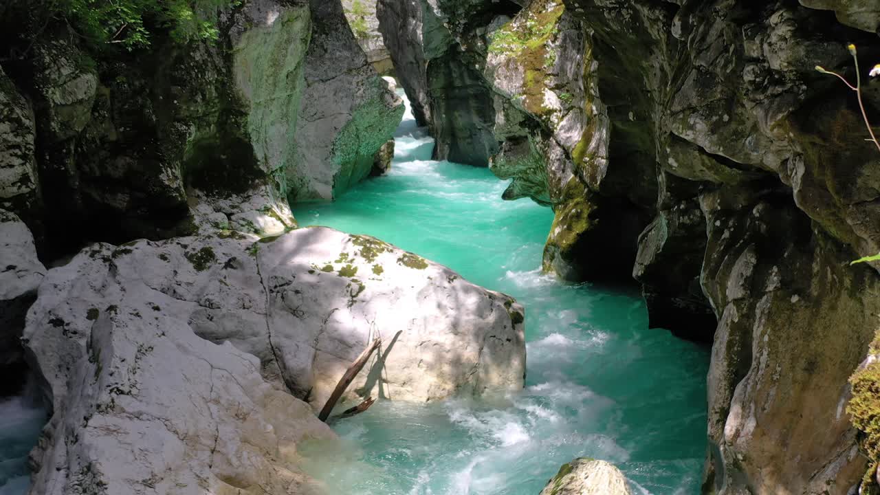 Dolly out of powerful Soca River running between limetone rocks near Boka Waterfall, Slovenia