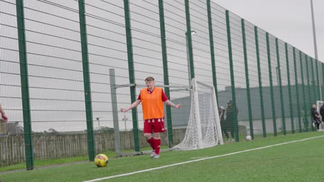 substitute players, wearing bibs, chatting, soccer ball kicking