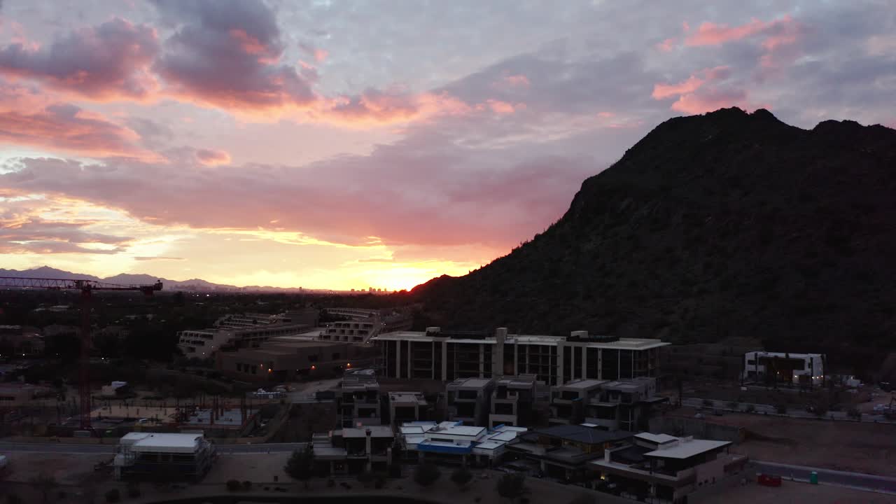 Drone shot of The Phoenician resting under the setting sun and Camelback Mountain in Arizona