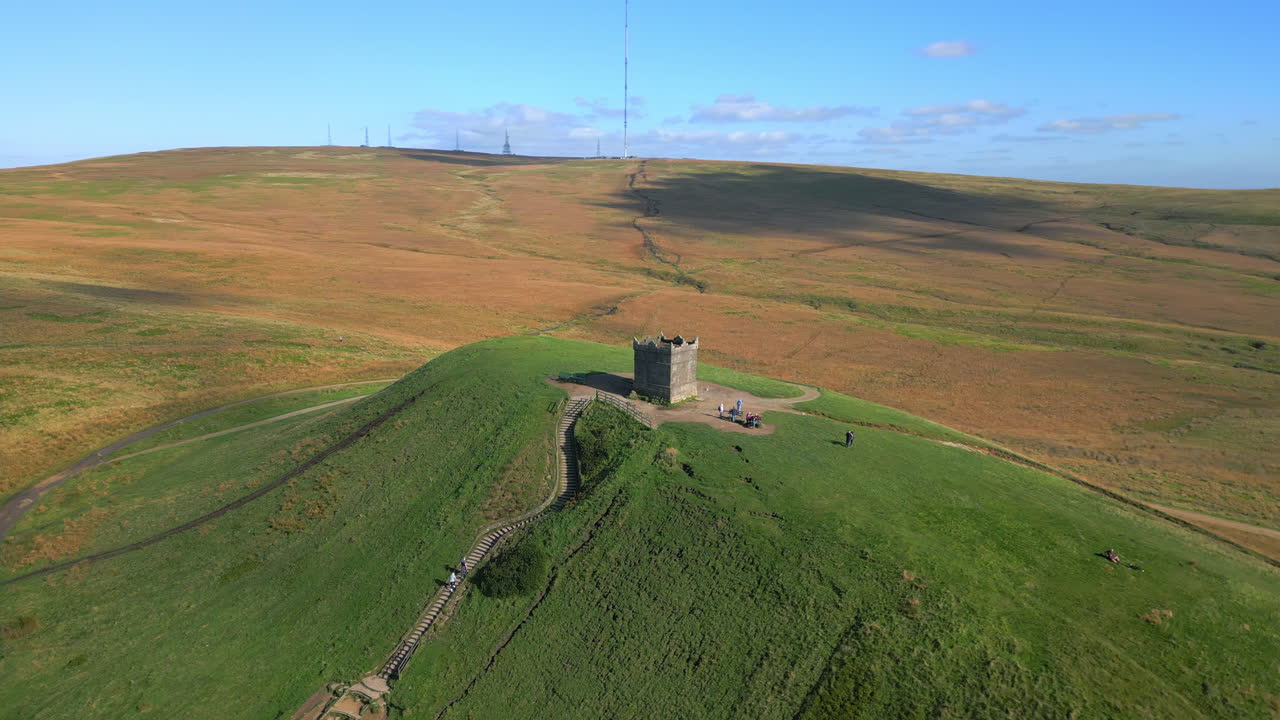 돌 구조와 높은 라디오 송신기가 뒤에 있는 언덕 꼭대기, 가을 색 ⁇