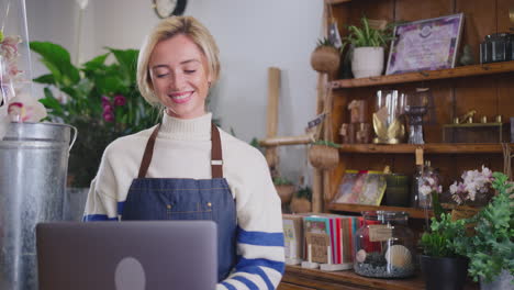 female owner of florists shop using laptop computer