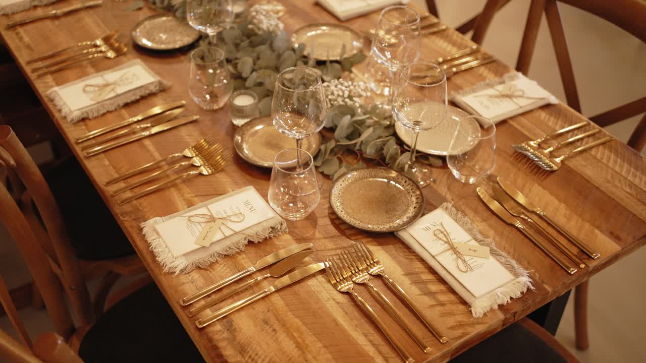 Rustic wood table with gold cutlery and soft napkins set for wedding dinner celebration