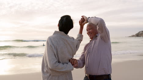 senior couple, beach and dancing outdoor at sunset