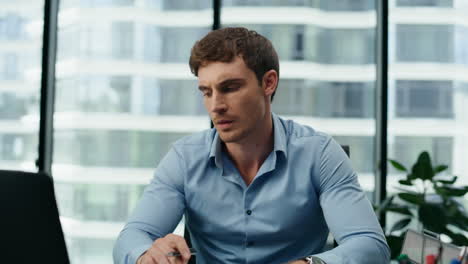 man entrepreneur feeling exhausted working at office desk with laptop close up