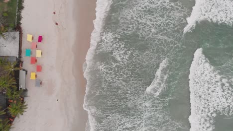 Top-view-of-the-sea,-drone-footage-,-cloudy-day,-waves,-landscape-of-Juquehy-beach,-Ubatuba,-northern-coast-of-São-Paulo,-Brazil