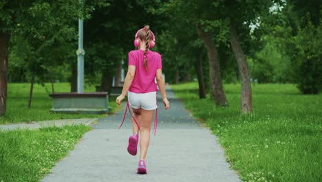 a young girl enjoys her time outdoors wearing headphones, embracing the joy of music while dancing in a serene park environment