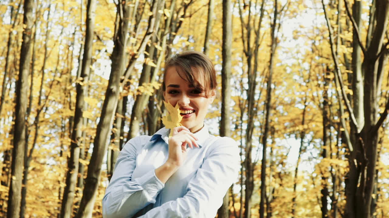 Beautiful female dreaming in the autumn park. Cheerful beautiful girl outdoors on beautiful fall day