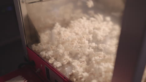 pop corn popping and filling up classic style pop corn machine - ungraded