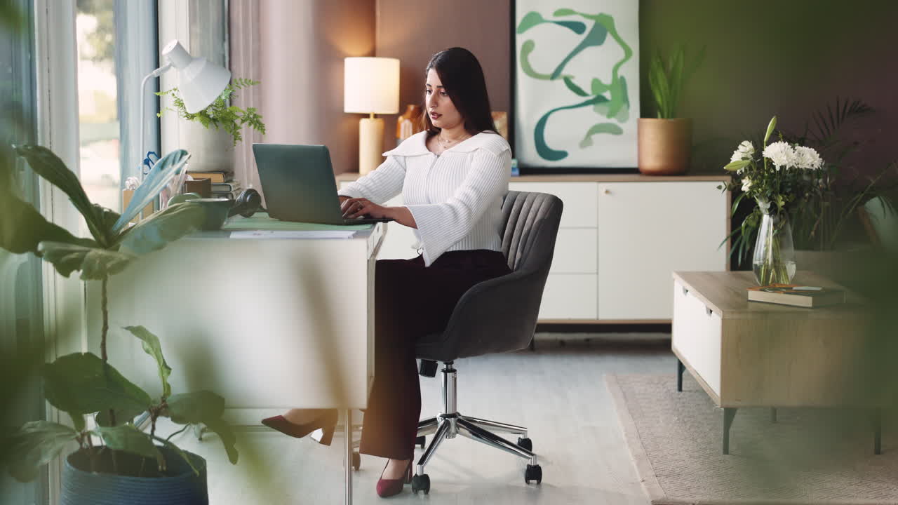 Stressed woman working on laptop in home office