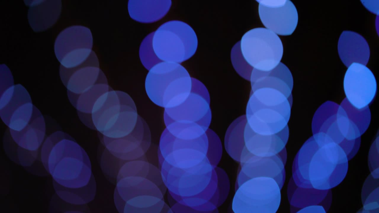 luces bokeh de sombras azules que se mueven hacia arriba sobre un fondo negro