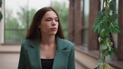 mujer en un blazer verde sentada en un columpio