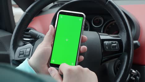 un hombre en un coche con una pantalla verde de teléfono