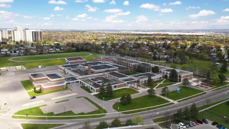 drone dando vueltas alrededor de la escuela con paneles solares en un soleado barrio suburbano