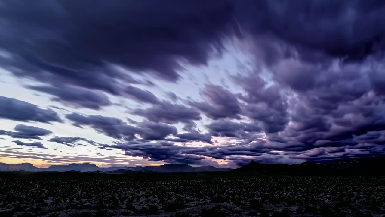 Dramatic time-lapse video capturing storm clouds rolling over a vast desert landscape