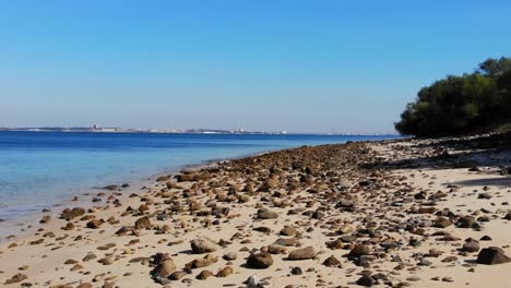 Drone-shot-flying-low-over-the-beach-at-Troia,-Portugal