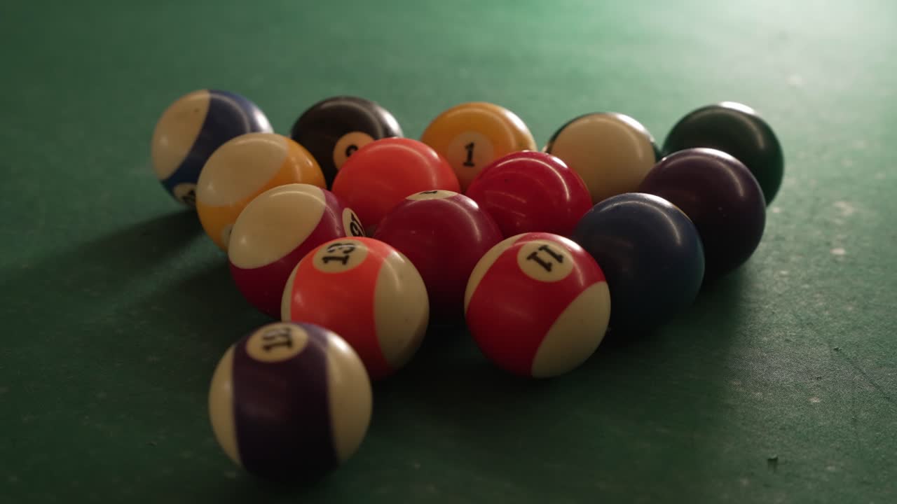 Close up of front billiard ball spun by hand before break on green pool table