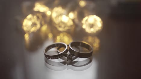 wedding rings displayed elegantly with bokeh lighting and smoke passing by