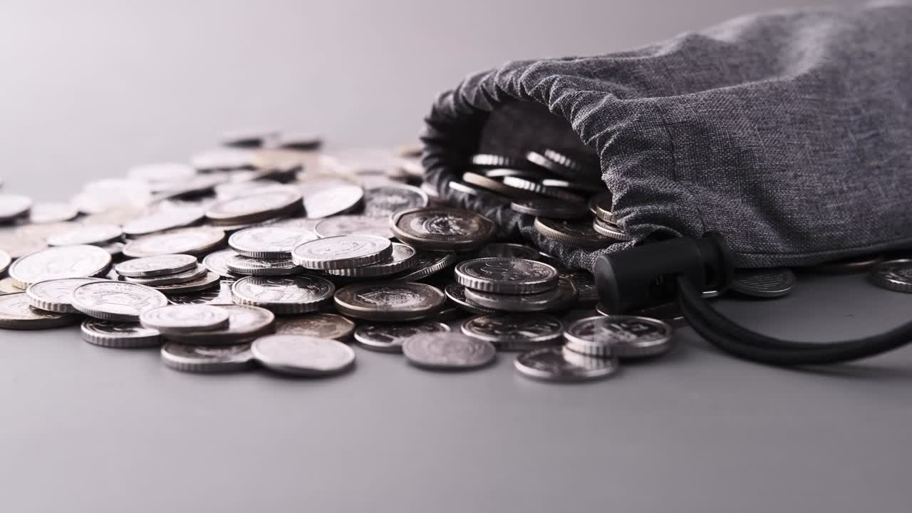 작은 가방 에서 흘러내리는 동전 의 근접 사진