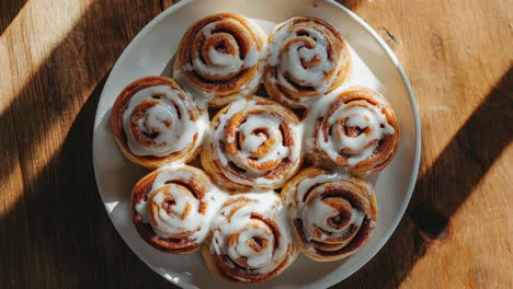 close-up of a plate of freshly baked cinnamon rolls on a wooden table