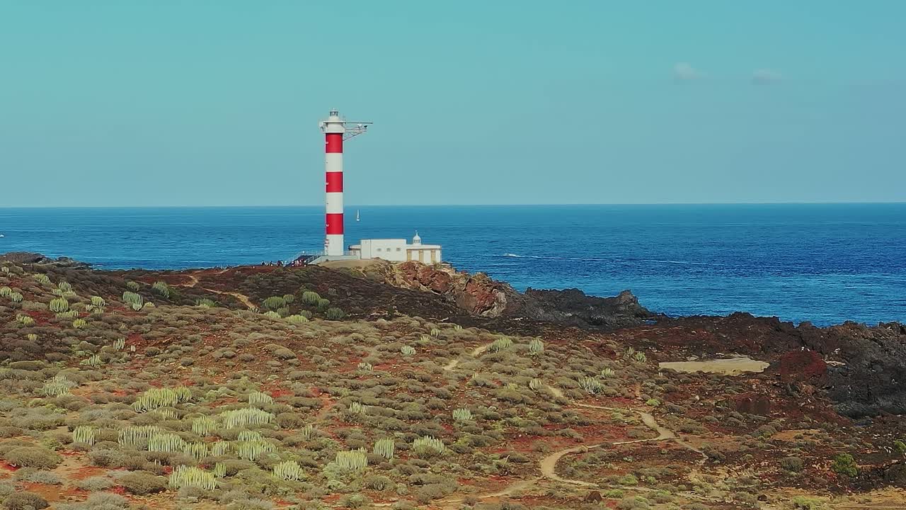 Faro sulla costa di Tenerife vicino all'oceano e al paesaggio roccioso