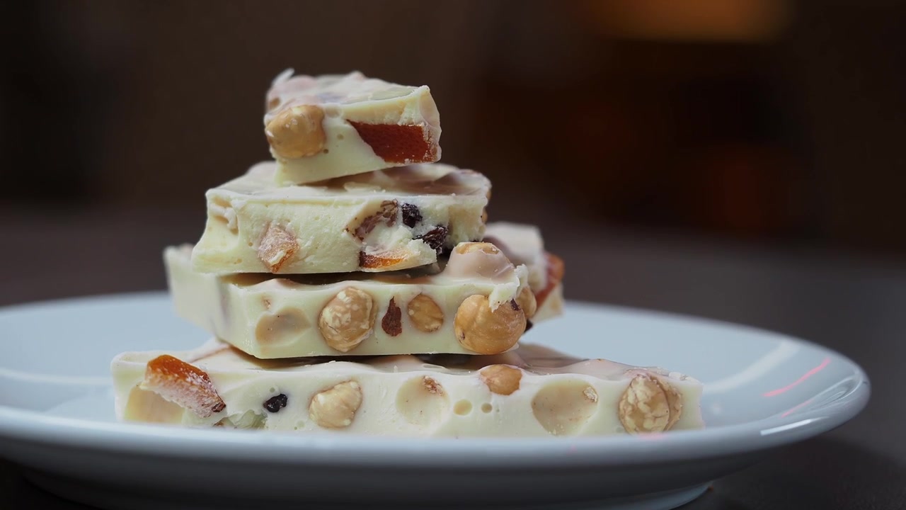 Hand Picking a Piece of White Chocolate with Nuts