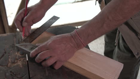 tomando medidas de la pieza de madera con línea y lápiz
