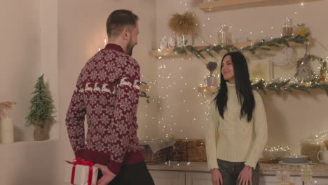 man giving a surprise christmas gift for woman at home