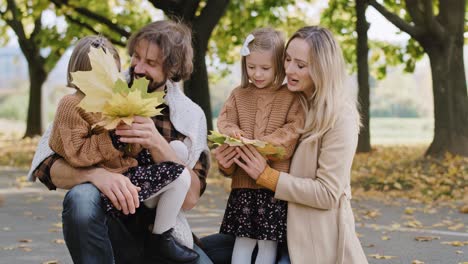 parents and children picking leafs on the fall season