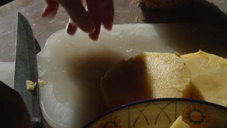 manos cortando piña en pedazos, cerrar, cámara lenta