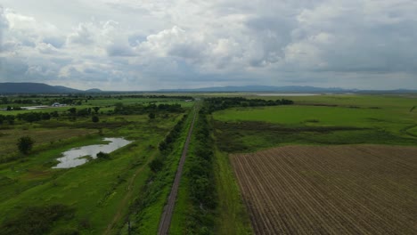 Imágenes-Aéreas-Descendentes-Que-Revelan-Un-Hermoso-Horizonte,-Ferrocarril-Provincial,-Tierras-De-Cultivo,