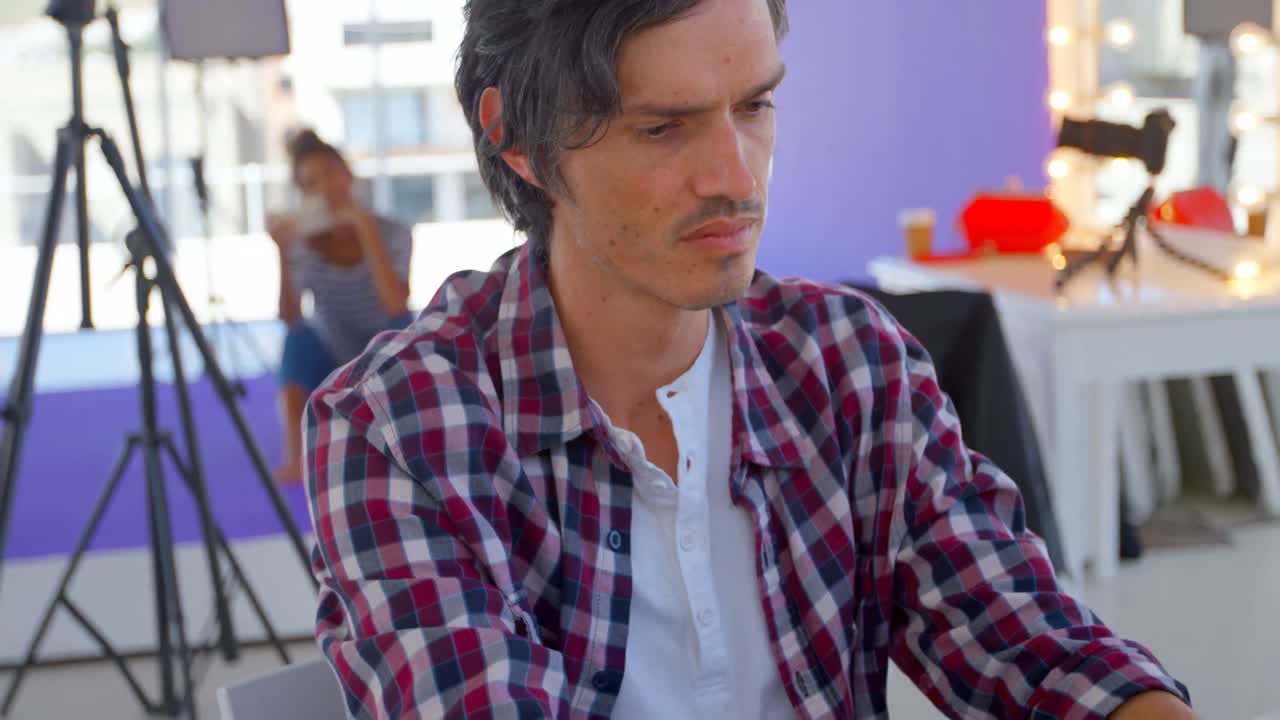 fotógrafo masculino usando una computadora portátil en un estudio fotográfico 4k