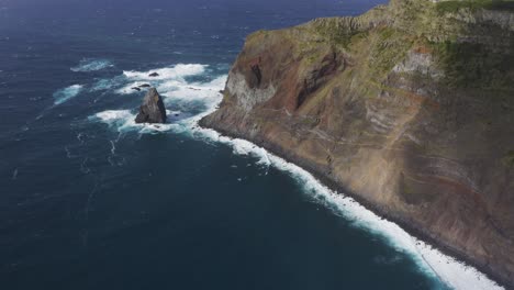 Drohnenaufnahmen-Von-Oben-Nach-Unten-Von-Wellen,-Die-Auf-Dramatische-Klippen-Schlagen-Und-Einen-Leuchtturm-über-Dem-Atlantik-Auf-Der-Insel-Sao-Jorge,-Azoren,-Portugal,-Enthüllen