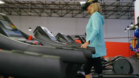senior woman using virtual reality headset on treadmill 4k