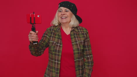 blogger mujer tomar selfie en teléfono móvil selfie stick comunicarse llamada de video en línea con el suscriptor