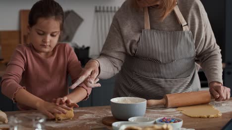 caucasian girl baking cookies with grandmother