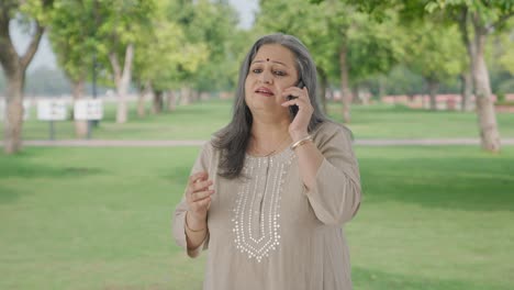 Indian-old-woman-talking-on-call-in-park